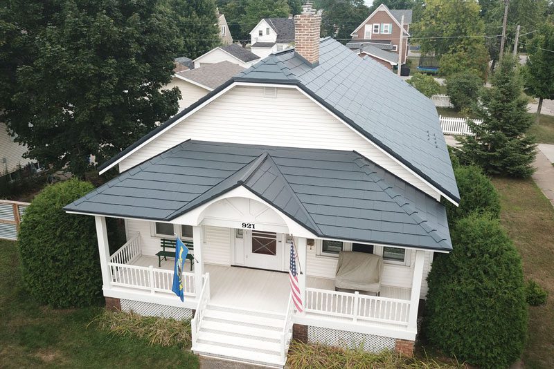 White home with green Oxford Shingle Metal Roofing