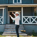 Roofing contractor inspecting roof of a blue log home